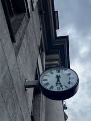 A striking view of a vintage clock mounted on the side of a historic building, set against an...