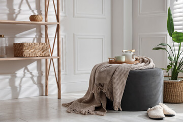 Stylish pouf with tea set at home