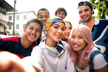 Group of multiethnic teenagers spending time outdoor and having fun