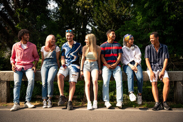 Group of multiethnic teenagers spending time outdoor and having fun