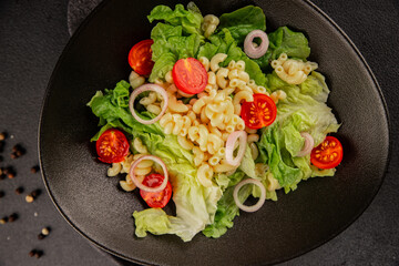 Pasta salad green leaf lettuce, tomato, pasta, onion fresh delicious gourmet food background on the table rustic food top view copy space keto and paleo diet vegan and vegetarian food
