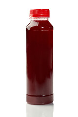 Plastic bottle containing red cherry juice on white background