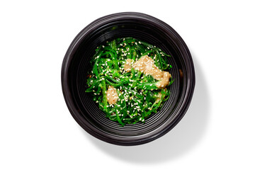 Japanese chuka seaweed salad with sesame seeds and sauce in black bowl