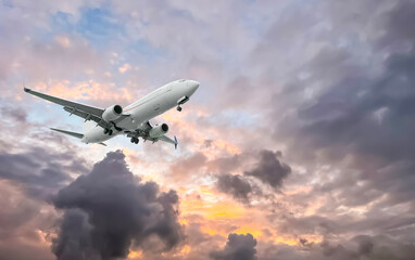 Airplane flying in beautiful sky with clouds at sunset