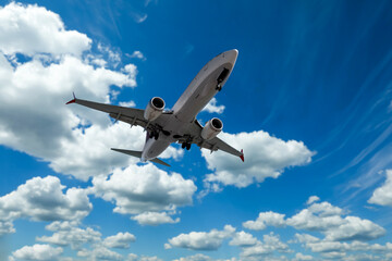Airplane flying in beautiful blue sky with clouds