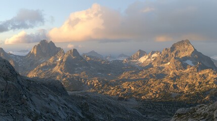 Fototapeta premium Mountainous landscape at dawn with dramatic peaks and clouds.