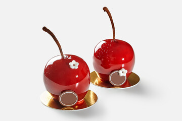 Two cherry-shaped desserts resting on golden coasters, showcasing culinary artistry
