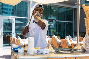 Dubai UAE - 22 July 2025:  Ice cream vendor and cone presentation, street food, Dubai Marina...