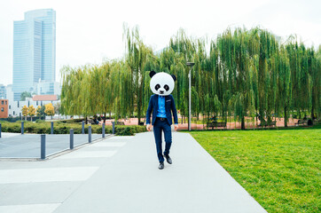 Storytelling image of a business man wearing a giant panda head