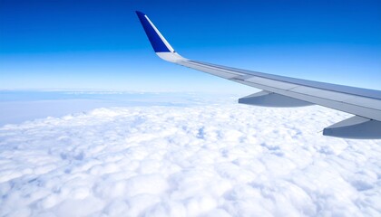 Fototapeta premium Airplane wing above clouds.View from airplane window a blue sky and clouds.