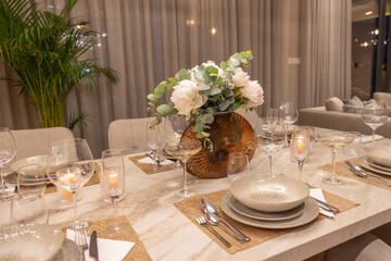 Elegant Dining Table Setting with Floral Centerpiece, Soft Lighting, and Sophisticated Tableware for a Memorable Gathering Experience