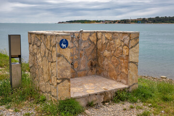Stone outdoor shower station with dog washing sign