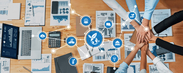 Aerial view of diverse business professionals collaborating over data charts and digital tools, fostering innovation and sustainable growth in a modern workspace. Amity