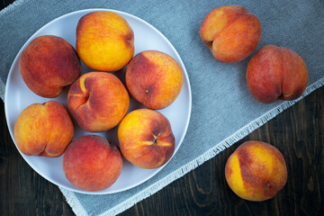 Perfect shape peaches. Large real peaches on plate and grey napkin background