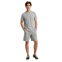 Fototapeta premium Young man in casual grey t shirt and shorts standing with hands in pockets looking at camera, isolated on transparent background.