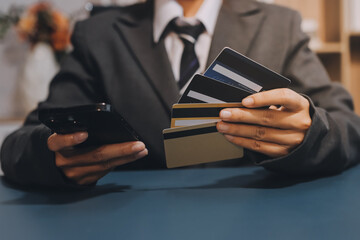 Online payment,businessman hands holding credit card and using  laptop for online shopping. Cyber...