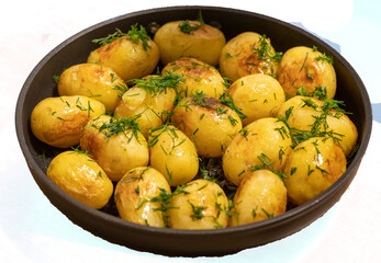 Young jacket potatoes fried in a frying pan and sprinkled with herbs on transparent background 