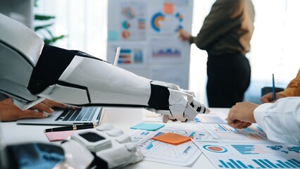 Robotic arm supports human team in a modern office setting, facilitating data analysis and...