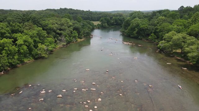 Areal view of kayak paddling on the Etowah River lined by trees in Northern Georgia
