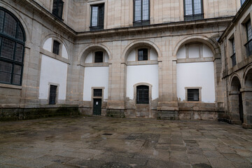Exploring the historical architecture and serene courtyard of Monasterio de El Escorial in Spain during a cloudy day