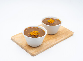 Classic Sticky Toffee Pudding Bowls with Caramel Sauce and Orange Zest Garnish on wooden board side view of dessert menus