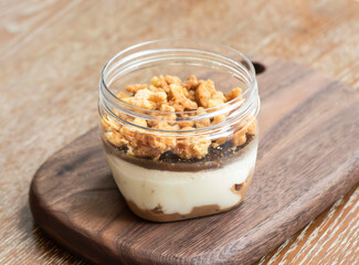 Yuen Yeung Tiramisu in a Jar with Crumble on wooden board side view of Fusion Dessert