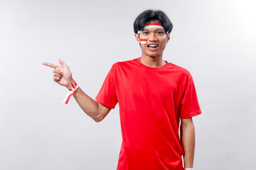 Young Indonesian man celebrating Independence Day with joyful expression, wearing red shirt and...