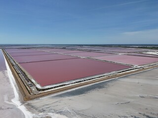 Aerial view of pink evaporation seawater ponds that leaves behind white sea salt—ideal for environmental, industrial, foot and travel content