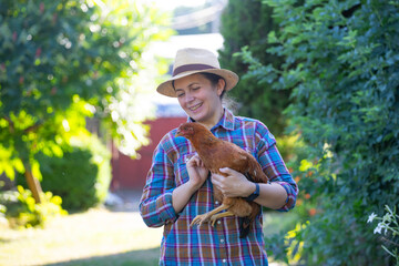 Happy young woman with a brown hen