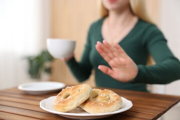 Gluten free diet. Woman refusing from pretzels indoors, selective focus