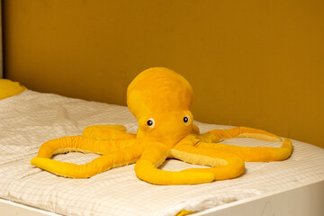 Cute Yellow Plush Octopus Toy Resting on Child’s Bed