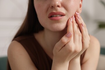 Woman suffering from toothache at home, closeup