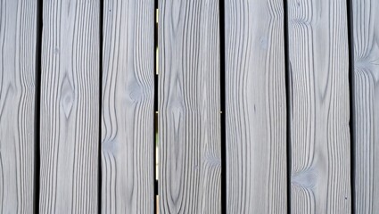 A close up view of a wooden fence with gray paint showing the natural wood grain pattern detail