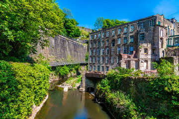 A  view up the River Goyt towards a disused mill beside the Torrs Riverside walkway at New Mills, High Peak in the UK in summertime © Nicola