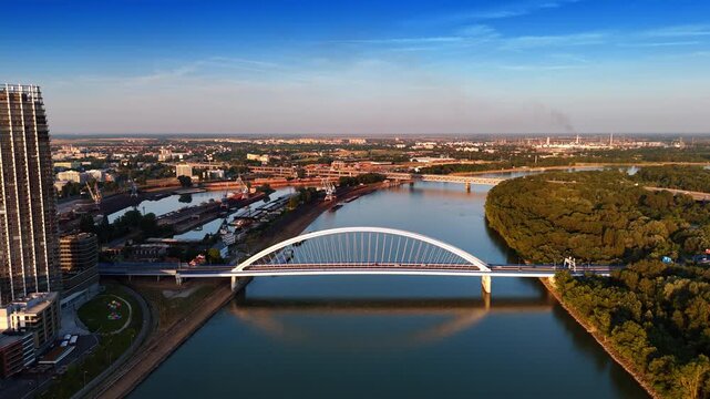 Sunset view of the Danube in Bratislava, Slovakia. Drone descending above the waterscape with the view on the Appolo Bridge.