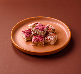 Nougat or white caramel with hazelnuts and strawberry pieces. White nougat