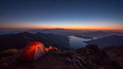 Mountaintop campsite at sunrise over a serene lake.