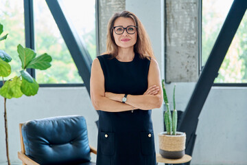 Portrait of middle-aged confident business woman looking at camera