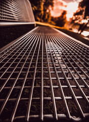 Top-down view of a metal grid floor at sunset with strong leading lines.