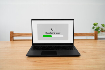 Calculating taxes using specialized software on laptop.