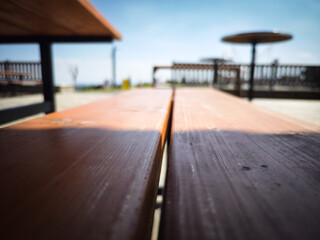 A close-up of a wooden tabletop with a blurred background. It evokes a feeling of summer, calm, and outdoor togetherness.