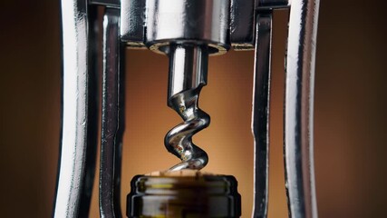 Corkscrew opening wine bottle. Close-up of tool and bottle neck.