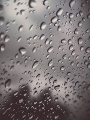 Fine raindrops on a light windowpane – soft light in the background.