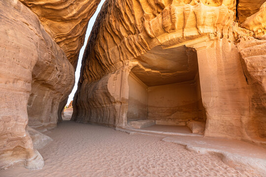 Sunlight illuminates Jabal Ithlib, Diwan and the Siq rock-cut tombs in Hegra, Al-Ula, Saudi Arabia, showcasing the ancient Nabataean architecture and the stunning desert landscape in Saudi Arabia
