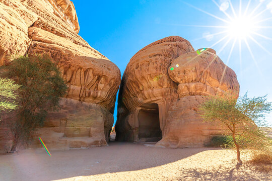Sunlight illuminates Jabal Ithlib, Diwan and the Siq rock-cut tombs in Hegra, Al-Ula, Saudi Arabia, showcasing the ancient Nabataean architecture and the stunning desert landscape in Saudi Arabia