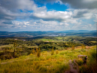  Gentle green hills beneath a cloudy sky – wide landscape view with depth and perspective.