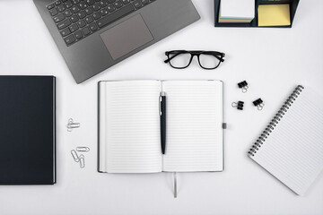 Top view of office table with laptop, pen, nootbook, glasses and stationery in home office room, clipping path. Desktop mock up.