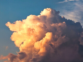 Dramatic golden cloud formations glowing in the warm late afternoon light. Soft yet impressive structures.