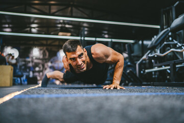 Fototapeta premium young adult man bodybuilder doing push ups exercise training in the gym