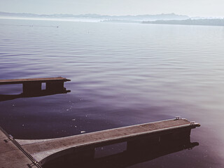 A wooden pier stretches over still water with soft ripples – peaceful and contemplative.